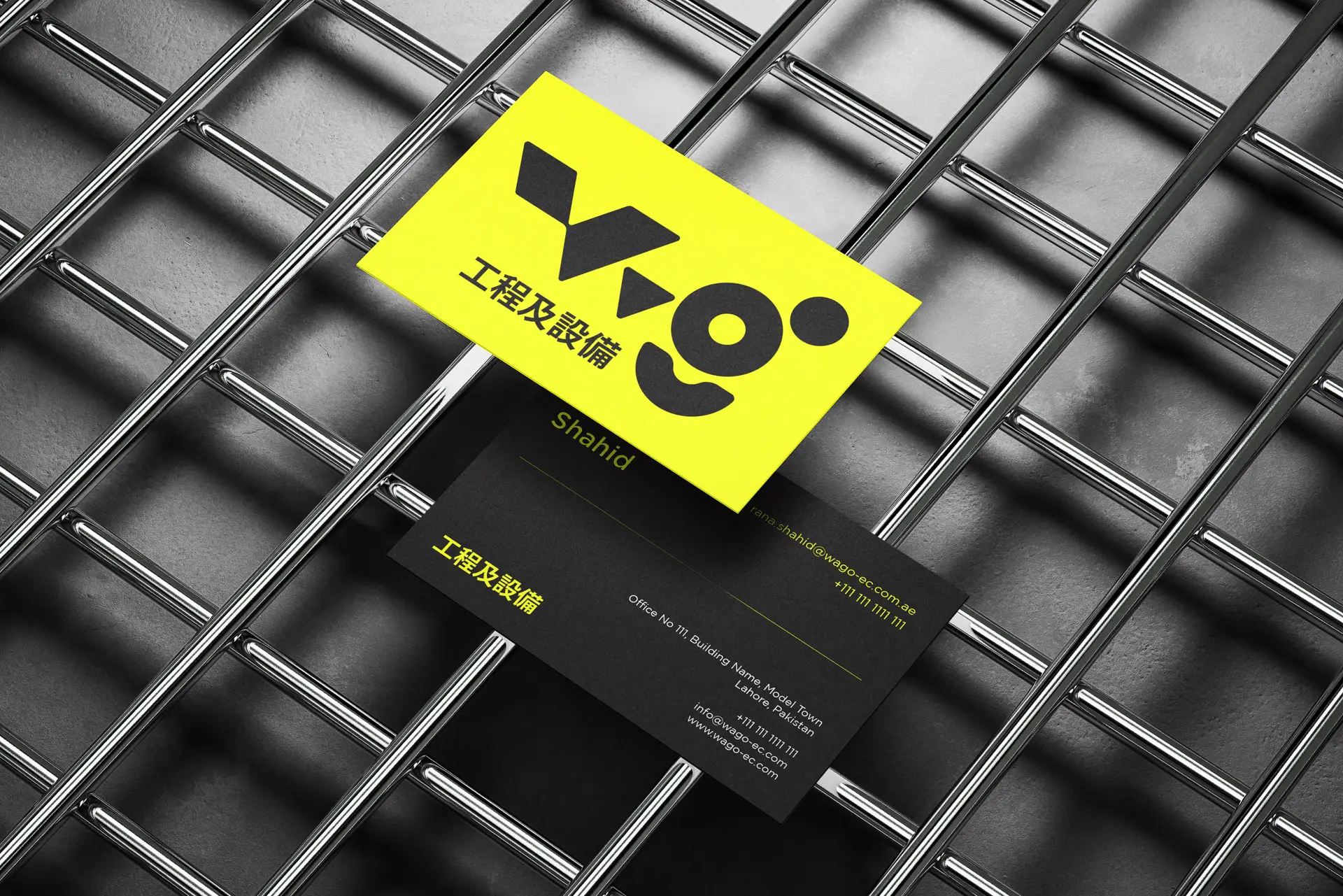 Image of business cards for WAGO, an automation engineering company, feature a high-contrast black and neon yellow design. The logo represents connection and growth using bold, geometric shapes. Contact details on the card indicate a presence in Lahore, Pakistan.