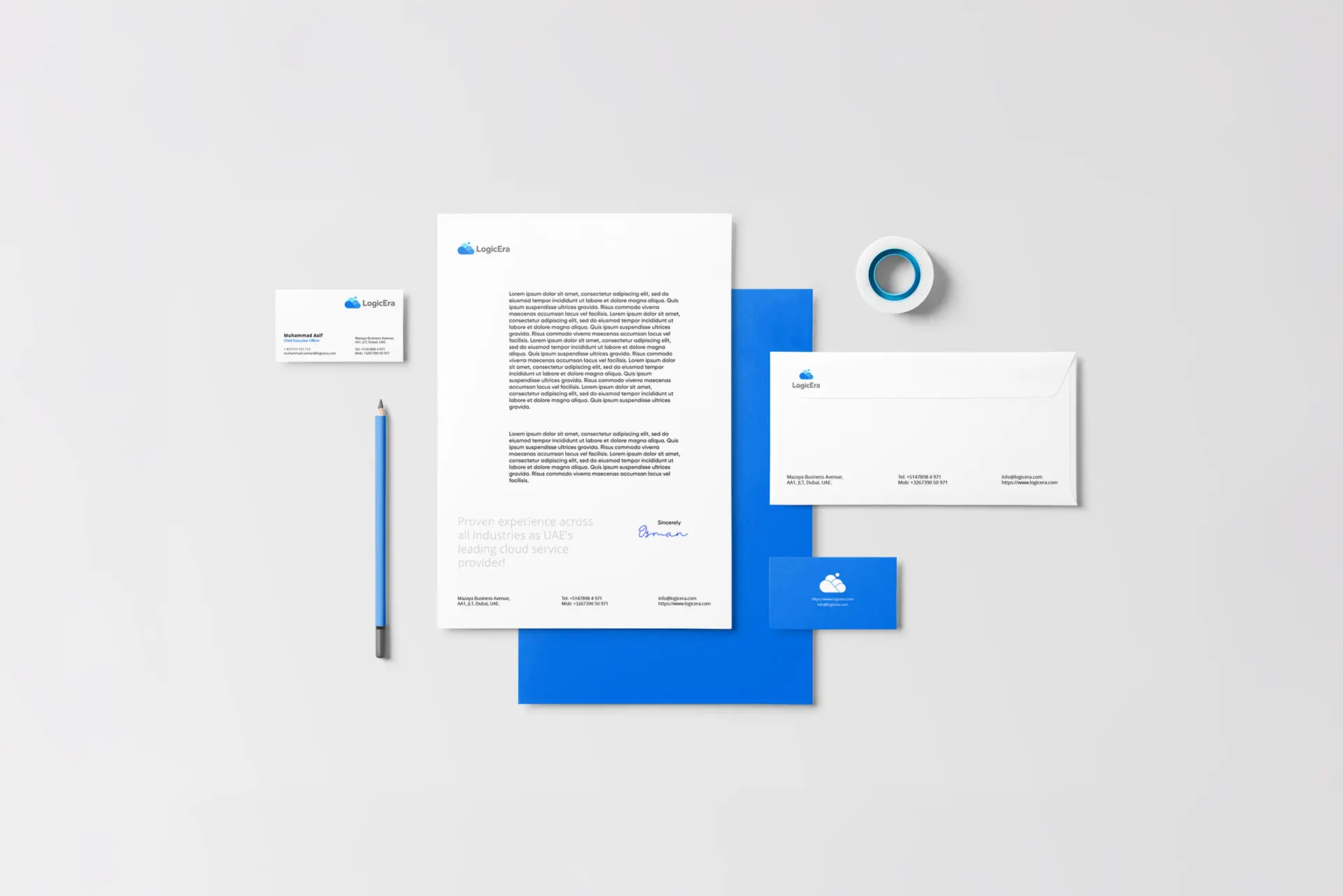 This image showcases a corporate identity kit (or stationery mockup) for a brand named LogicEra. The collection uses a clean, professional aesthetic with a blue and white color palette. It includes: Letterhead: A standard A4 or US Letter page with the company logo and placeholder text. Envelopes: Matching white and blue branded envelopes. Business Cards: Displaying the contact information and logo on both white and blue backgrounds. Folder: A solid blue presentation folder to hold documents. Accessories: A branded pencil and a roll of tape to complete the office theme. These mockups are commonly used by designers to present how a logo and brand elements will look in real-world business applications.